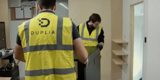 The Duplia team moving a new rack cabinet into place on site